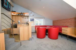 uma sala de estar com um sofá vermelho e uma mesa em A perfect option for people who want to enjoy their stay in Kosice em Košice