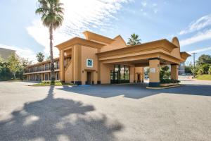 een gebouw met een palmboom ervoor bij Quality Inn Tallahassee near University in Tallahassee