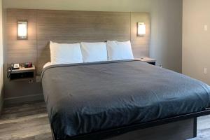 a large bed in a hotel room with two tables at Suburban Studios near Panama City Beach in Panama City