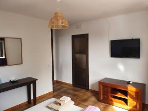 ein Wohnzimmer mit einem TV, einem Sofa und einem Tisch in der Unterkunft Casaflor in Mojácar