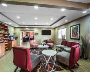 Quality Inn Plant City - Lakeland في بلانت سيتي: غرفة معيشة مع أريكة وطاولة وكراسي