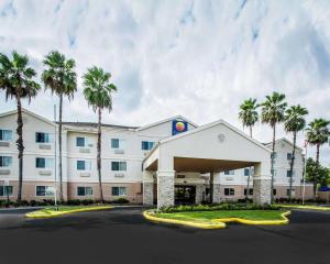 a hotel with palm trees in front of a building at Quality Inn Plant City - Lakeland in Plant City
