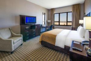 a hotel room with a bed and a television at Clarion Inn & Suites Miami International Airport in Miami