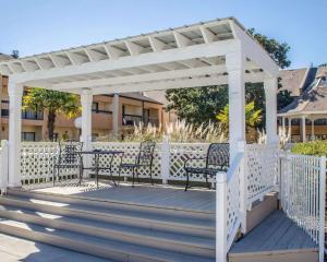 une pergola blanche avec deux bancs sur une terrasse dans l'établissement Quality Inn & Suites Pensacola Bayview, à Pensacola