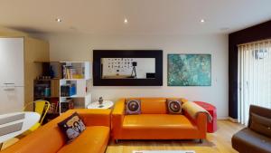 sala de estar con sofá naranja y mesa en Central Perks Apartment (sleeps 4) en Hull