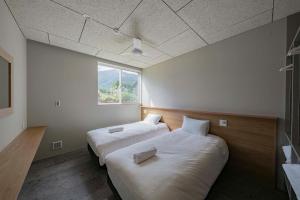 - 2 lits dans une chambre avec fenêtre dans l'établissement Echo Rocks by The Hakuba Collection, à Hakuba
