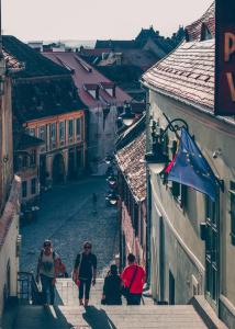 un grupo de personas caminando por una calle de la ciudad en Gasthof Sara, en Sibiu