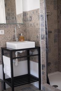 een badkamer met een wastafel en een douche bij Casa Da Cabeça in Faro