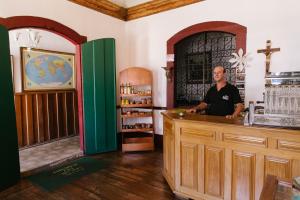 a man standing at a counter in a room at Pousada Solar do Carmo in Ouro Preto