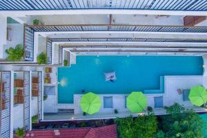 una vista aérea de una piscina con sombrillas verdes en Wabi Sabi Boutique Hotel - SHA Extra Plus en Kamala Beach