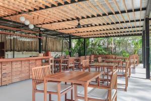 ein Restaurant im Freien mit Holztischen und -stühlen in der Unterkunft Wabi Sabi Boutique Hotel - SHA Extra Plus in Kamala Beach
