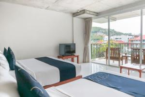 ein Hotelzimmer mit 2 Betten und einem Balkon in der Unterkunft Wabi Sabi Boutique Hotel - SHA Extra Plus in Kamala Beach + 37 Fotos