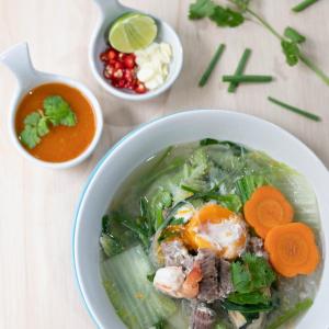 a bowl of soup with meat and vegetables and carrots at Montree Phuket Hotel in Phuket Town