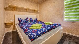 a bedroom with a bed with a blue and white comforter at Feriendorf Fynnus in Dranske