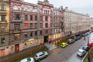 聖彼得堡的住宿－涅夫斯基洛厄舒適公寓，一条城市街道,汽车停在建筑前