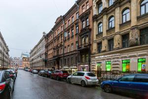 聖彼得堡的住宿－涅夫斯基洛厄舒適公寓，停在城市街道上的一排汽车,街道上有很多建筑