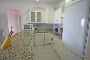 エンプリアブラバにあるApart-rent Apartment Sant Maurici 0183の白いキャビネット、シンク、電子レンジ付きのキッチンが備わります。