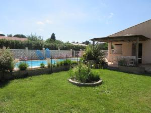 einen Garten mit einem Zaun und einem Pool in der Unterkunft Studio agréable et très lumineux (Salles d'Aude) in Salles-dʼAude