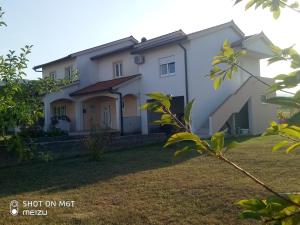 a large white house with a yard at Apartmani Darko in Međugorje