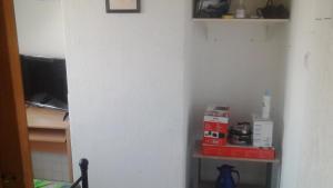 a corner of a kitchen with a shelf in a room at PrivateRoomsAE in Essen