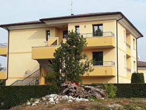 een geel huis met een boom ervoor bij Albergo Al Portico in Azzano Decimo