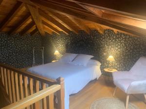 a bedroom with a white bed and a chair at Palacio de Arce in Puente Arce