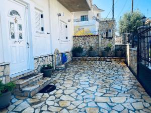 a house with a stone walkway in front of a door at See and City Apartment in Aigio