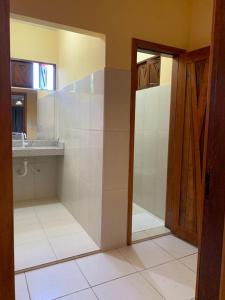 uma casa de banho com uma cabina de duche ao nível do chão e um lavatório. em Agualinda Hotel em Alter do Chão