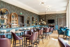 布拉克内尔Easthampstead Park的带酒吧的餐厅，酒吧里有椅子和桌子