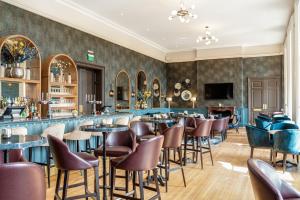 a restaurant with a bar with chairs and tables at Easthampstead Park in Bracknell