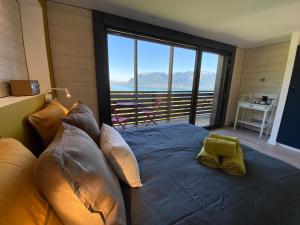 um quarto com uma cama e uma janela grande em Les Ô d'Annecy em Saint-Jorioz