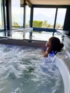 een jong meisje liggend in een jacuzzi bij Les Ô d'Annecy in Saint-Jorioz