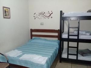 a bedroom with two bunk beds and a ladder at Pousada Oceanica in Praia Grande