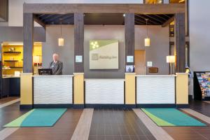 a man standing at a counter in a lobby at Holiday Inn Morgantown - Reading Area, an IHG Hotel in New Morgan