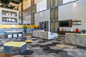 an office lobby with a tv and couches at Holiday Inn Morgantown - Reading Area by IHG in Morgantown
