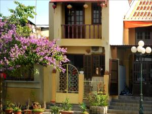 a house with purple flowers in front of it at Nha Lan Homestay in Hoi An