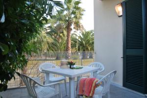 a white table and chairs on a patio with palm trees at Vaia Residence in Torre dell'Orso