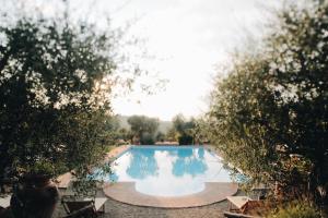basen otoczony drzewami i krzesłami w obiekcie Tenuta Sant'Ilario w mieście Gambassi Terme