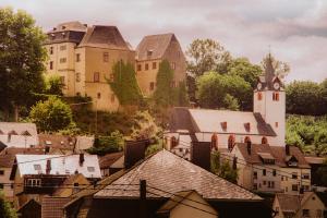 a group of buildings in a town with a church at Alte Landratsvilla Hotel Bender in Westerburg