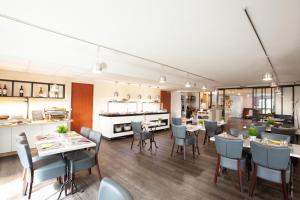 サン・プリエストにあるBest Hotel Lyon - Saint Priestのテーブルと椅子のあるレストラン、キッチンが備わります。