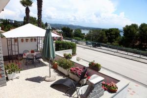 a patio with an umbrella and a table with flowers at Beautiful Bay View Apartment Portoroz IU in Portorož