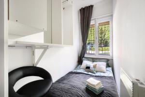 a small bedroom with a bed and a window at Buda Centre Homes by the Allee Shopping Mall in Budapest