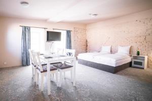 pokój hotelowy z łóżkiem, stołem i krzesłami w obiekcie Penzion Papírna w mieście Cheb
