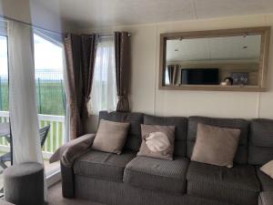 a living room with a couch and a mirror at Emmanuel Holiday Home in Whitley Bay