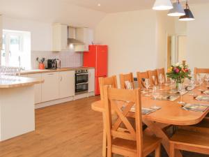 una cucina e una sala da pranzo con tavolo e sedie in legno di Black Lion Barn Retreat a Shrewsbury