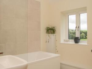a white bathroom with a tub and a window at Black Lion Barn Retreat in Shrewsbury +31 photos
