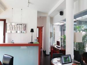 ein Büro mit einem Schreibtisch und einem Tisch mit einem Laptop in der Unterkunft Chic Quarter in Jakarta