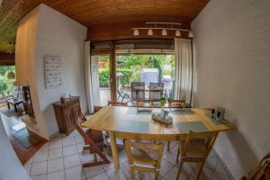 a dining room with a wooden table and chairs at Ferienhaus im Bestetal in Bad Oldesloe