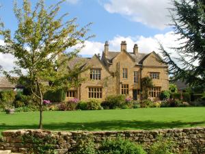 an old stone house with a tree in the yard at Mill Hay Country House in Broadway