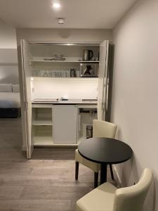 Zimmer mit einem Schreibtisch, einem Tisch und Stühlen in der Unterkunft Axiom Park Hotel in London